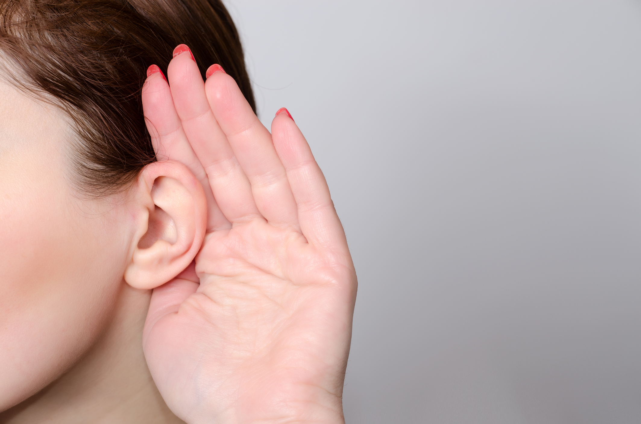 Person placing hand behind ear listening